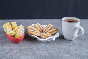 Cookie servings and a cup of tea on marble background