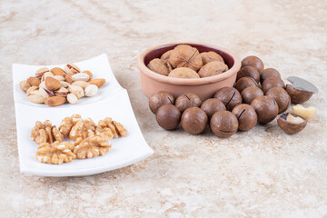 Chocolate balls, walnuts, almonds and pistachios on marble background