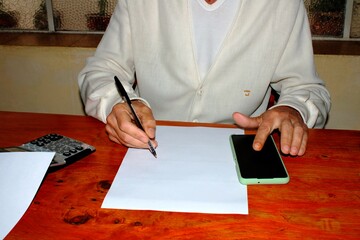 El profesional médico escribe una receta en su oficina en la mesa de madera lustrada haciendo...