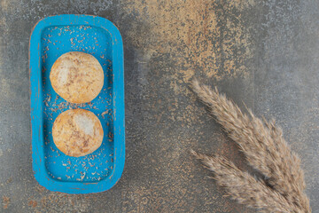 Delicious cookies on a blue platter on wooden background