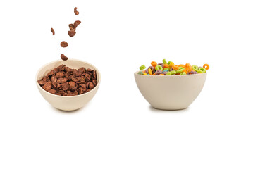 Chocolate corn flakes falling to the white bowl isolated on white. Motion.