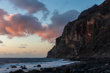 Scenic view during sunset on the volcanic sand beach Playa del Ingles in Valle Gran Rey, La Gomera, Canary Islands, Spain, Europe. Massive cliffs of the La Mercia range. Calm atmosphere at the seaside