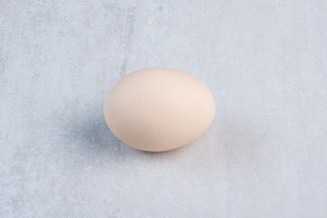 Single egg displayed on marble background