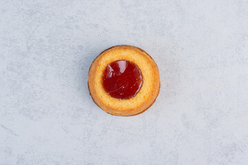 Small cake with jelly filling on marble background