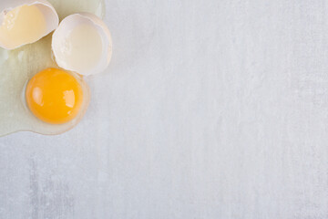 Single egg broken open on marble background