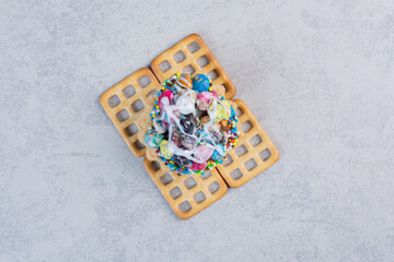 Cupcake with candy topping on crackers on marble background