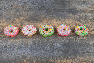 A row of bite-sized donuts on wooden background