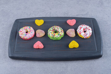 Navy board with marmelades and donuts on marble background