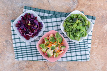 Freshly chopped vegetables mixed and bundled in bowls on marble background