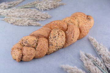 Strucia loaf amid stalks of decorative dried feather grass on marble background