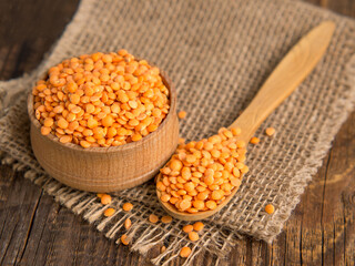 red lentils in a wooden bowl on a wooden background. Product photo of red lentils. healthy lifestyle