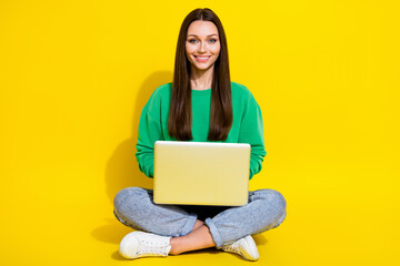 Full size photo of pretty young girl use laptop study remote college dressed trendy green sweatshirt isolated on yellow color background