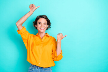 Photo of adorable gorgeous cute girl bob hairstyle wear yellow blouse directing empty space isolated on turquoise color background - obrazy, fototapety, plakaty