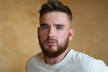 Fototapeta premium Portrait brutal handsome bearded man with blue eyes, male personal self care, products, accessory for growth style dark brown red beard. Lifestyle people
