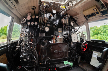 Führerstand einer alten Dampflokomotive mit den modernen Zugfung und PZB