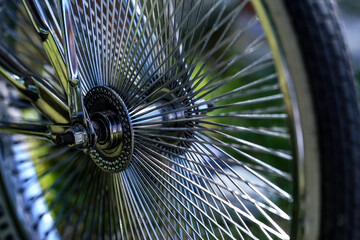 Shiny chrome bicycle spokes on a stylish wheel, closeup detail