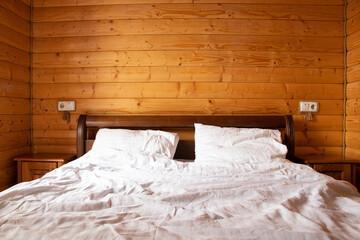 Double bed in a bedroom in a wooden house, apartment and interior, bed