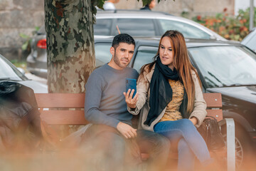 couple in the autumn in the park with mobile phone