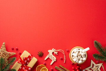 Christmas concept. Top view photo of wood ornaments pine branches craft paper giftbox wicker star cup of cocoa dried orange slices mistletoe berries cinnamon on isolated red background with copyspace