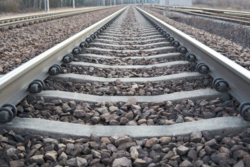Railway lines with track ballast. Train tracks underlay, rails and crushed stones. Industrial landscape. Railway junction. Heavy industry. Railway track. - obrazy, fototapety, plakaty