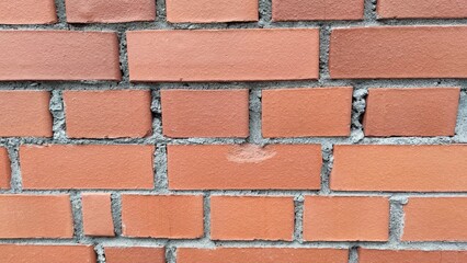 Obraz premium Smooth brick surface of different colors. Brick wall made of brown bricks. The bricks are laid out in different directions and have slightly different shades of brown.
