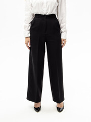 Women's black trousers on white background. Woman in pants, white shirt and shoes with heels. Clothes for work, college or school