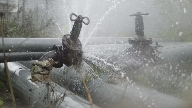 Burst pipe. Pipeline accident. Industrial disaster. Flow of boiling water. Spray of water. Breakdown on line.