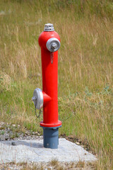 Ein Hydrant steht am Rand einer Grünfläche. Ein Oberflurhydrant.