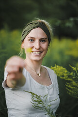 
happy alternative & spiritual looking hipster woman holding yellow flower into the cam like a...