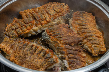The cook fries fresh crucian fish in a frying pan