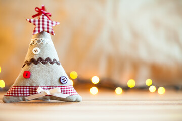 Small cloth christmas tree and blurred christmas lights in the background. Christmas decoration. - 534060013