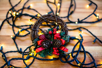 Christmas wreath on christmas lights and wooden table.