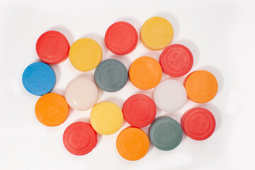 many colorful plastic bottle caps isolated on white surface
