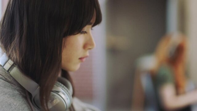 Focus, creative business woman on laptop at an Internet cafe, work desk or trendy office in Tokyo. Asian, gen z worker or student drink tea while working at digital marketing company for internship