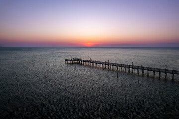 Fototapeta na wymiar The sun setting over a fishing pier off the Eastern Shore of Virginia 