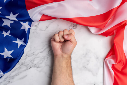 Background with a clenched fist surrounded by the flag of the United States of America. American pride and power. Struggle and strength for the American homeland
