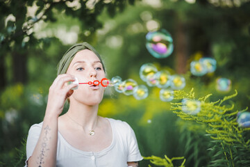 happy alternative & spiritual looking hipster girls makes soap bubbles & blows them in the air...