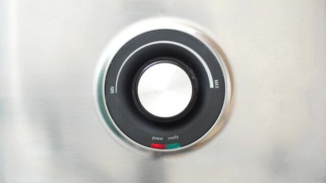 Macro shot of a power on lamp switching to green ready light on a power regulation knob