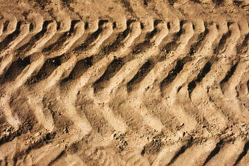 Tyre mark background. Tire track shape. Trail lines on dry brown sand pattern. Road construction...