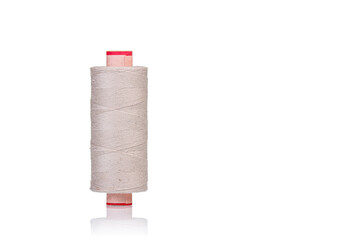 skein of beige color thread macro on a white background