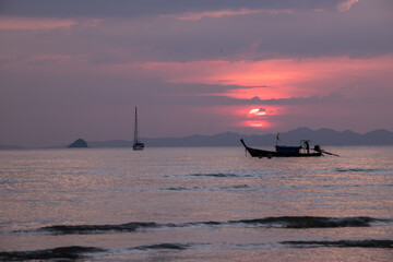 Atardecer rosa en el mar con  barco en el horizonte