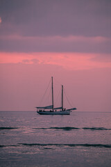 Fototapeta premium Atardecer rosa en el mar con barco en el horizonte