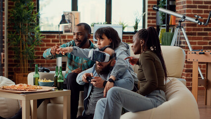 Cheerful people winning video games competition with vr glasses, celebrating gaming win on tv console. Feeling happy about online challenge with virtual reality headset. Handheld shot.