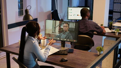 Business people attending online videocall meeting on computer, talking on teleconference. Using...