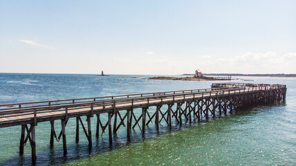 Fototapeta na wymiar Wooden pier by the beach and ocean in the summer