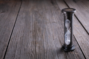 Hourglass on dark wooden background with copy space