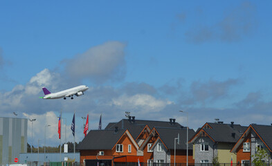 passenger plane clearing from an airport near a housing estate