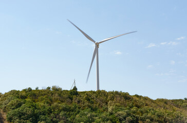 A wind generator standing on a hill generates electricity.