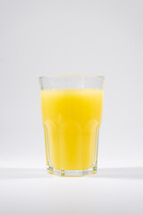 fresh yellow cold fruit juice with lemon, ice, straw isolated