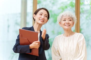 シニア女性に説明をするビジネスウーマン